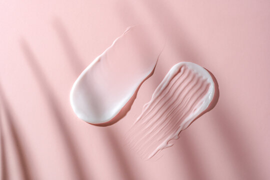 Cosmetic cream textures on a soft pink background