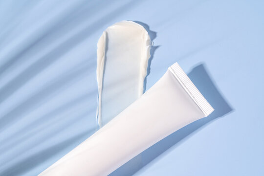 White cream texture with a tube on a blue background