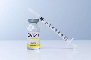 Vaccine in glass vial with syringe on a table. Vaccination, immunization, treatment to Covid 19 Corona Virus infection. Healthcare And Medical concept.