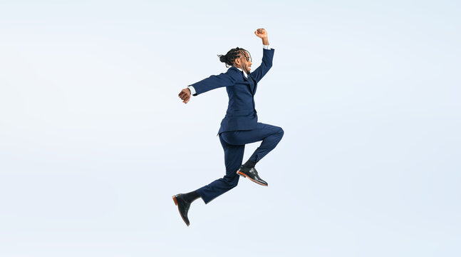 ジャンプする黒人男性ビジネスパーソンの全身写真