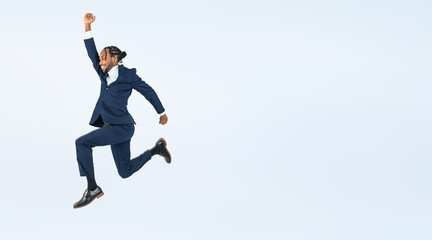 Fototapeta na wymiar Full body photo of a Black male business person jumping. (We also sell PNGs that are cropped and have transparent background. Please search for 