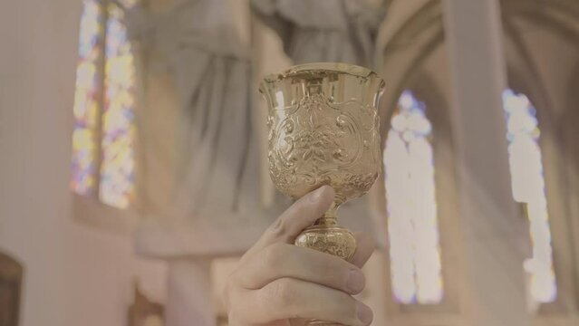 Chaplain hand holding communion wine golden chalice close up. Sacramental meal goblet closeup. Lords Supper ceremony celebration concept
