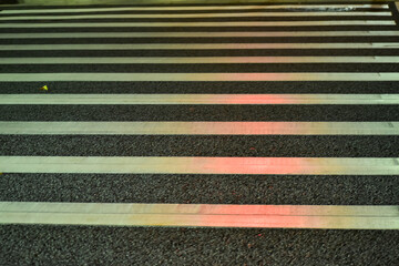 Close-up of zebra crossing at night. Cityscape, downtown scene.