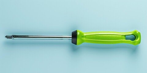 A green screwdriver placed on a blue background. Suitable for construction and DIY projects - obrazy, fototapety, plakaty