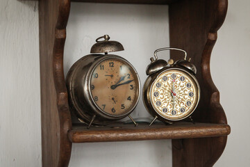 Old clocks on a wooden shelf. Vintage alarm clocks