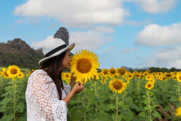 Happy young woman enjoying in yellow  sunflower field. Lifestyle Concep