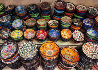 Round plates with multicolored traditional Oriental Arabic ornaments, on the shop window, in the assortment