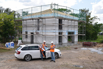 teamwork on the construction site - site manager and architect on site during the construction of a house - 791710860
