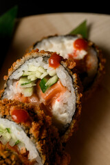Fried in flour sushi with rice, salmon, cream cheese and cucumbers or avocado