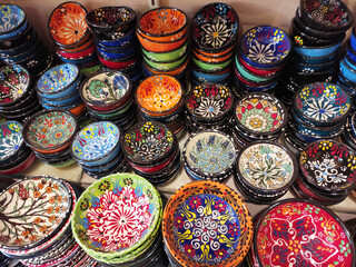 Fototapeta na wymiar Round plates with multicolored traditional Oriental Arabic ornaments, on the shop window, in the assortment
