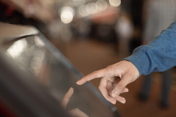 man hand touching interactive touchscreen display kiosk
