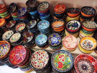Round plates with multicolored traditional Oriental Arabic ornaments, on the shop window, in the assortment