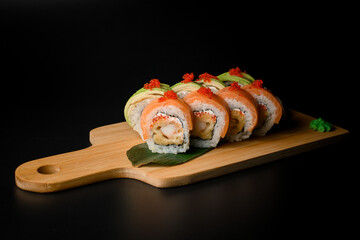 Black background with sushi set on a wood stand wrapped in salmon and avocado - 791718686