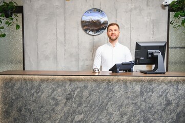 Portrait of receptionist at desk in lobby, hotel