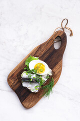 Spiced Sprat Sandwich Kiluleib or  Kiluvõileib - Estonian sandwich with spicy salted sprat, butter, boiled egg, fresh onion and herbs on a slice of national rye bread, natural eco Scandinavian style.