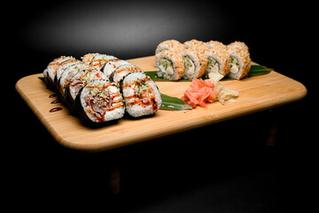 Assorted sushi set with seafood on a stand on a black background hot sauce - 791731282