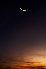 Crescent moon on dusk sky vertical on twilight well space for text Eid Al Adha