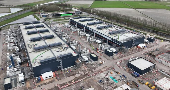 Aerial drone views the construction of a large scale big tech datacenter at Agriport, The Netherlands. Internet cloud and artifical intellgience infrastructure. Investement in data driven technology.