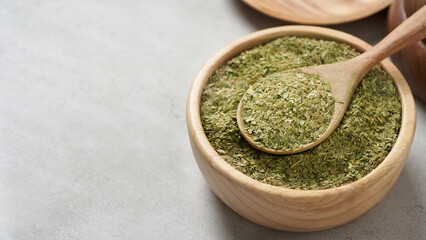 close up yerba mate tea leaves in wood bowl and spoon on white table food copy space background