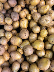 stack of raw potatoes in plastic container in market. Top view
