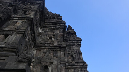 View of a temple in ancient Prambanan temple complex with clear blue sky background. Popular tourist destination. No People.