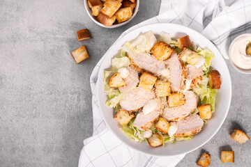 Chicken Caesar Salad in a Bowl with Parmesan Cheese, Dressing and Croutons
