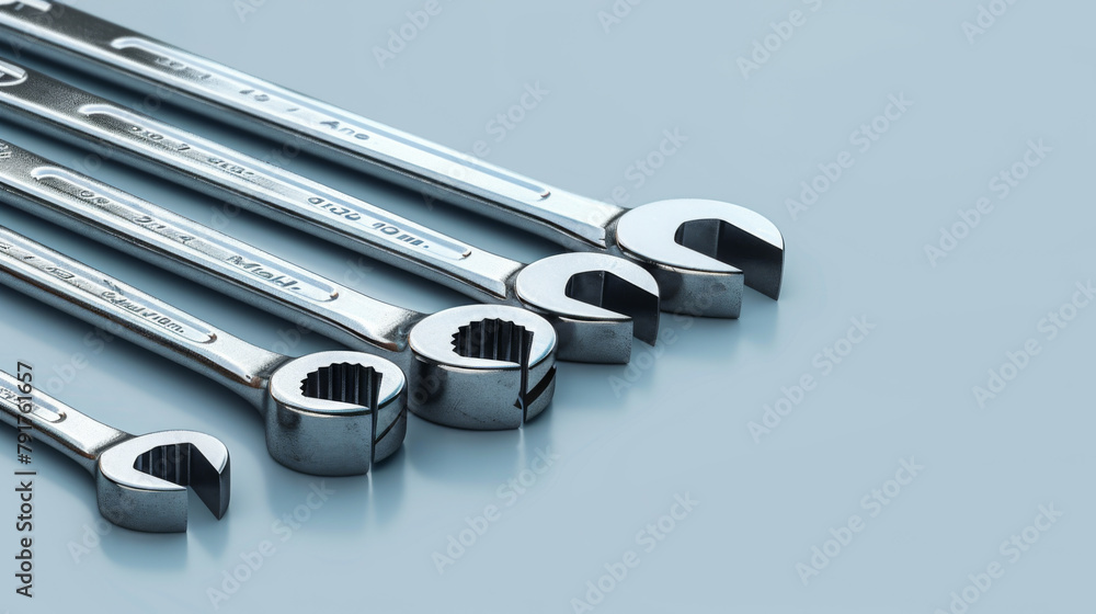Poster an array of chrome vanadium steel wrenches neatly aligned on a grey background.