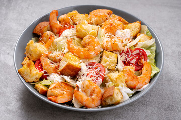 Shrimp Caesar Salad in a Bowl with Parmesan Cheese, Dressing and Croutons