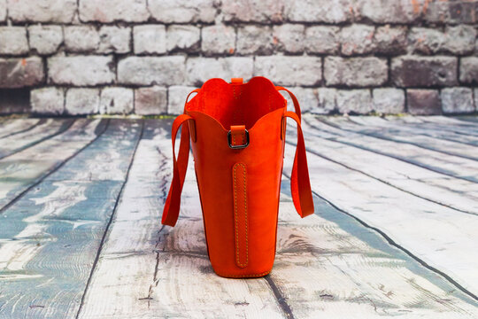 Women's red leather bag on wooden floor, photo for an e-commerce store catalog on a social network.