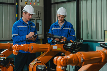 Teamwork of engineers men inspecting the Check quality of compact desktop robotic arm Engineer work...