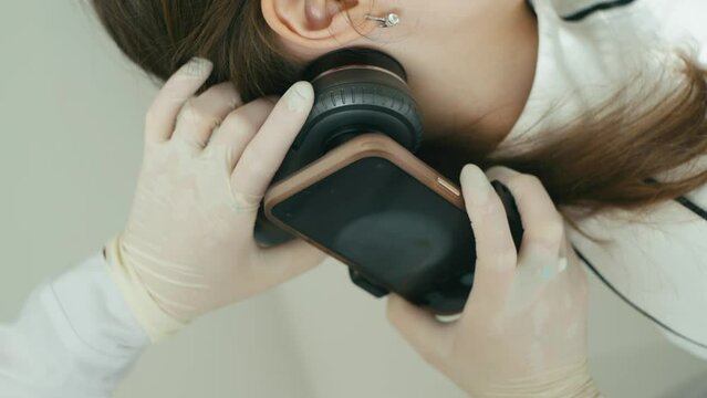 Vertical video on which moles are viewed with a special magnifying glass. The use of medical devices for the study of human skin. High quality 4k footage