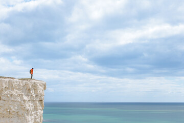 Seven sisters, Hiker standing next to the cliff, famous tourism location and world heritage in south England, Spring outdoor