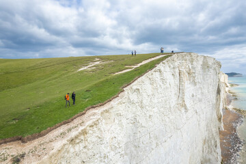 Seven sisters, Hikers walking along the coast, famous tourism location and world heritage in south England, Spring outdoor