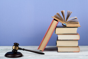 Law concept open book with wooden judges gavel on table in a courtroom or law enforcement office,...