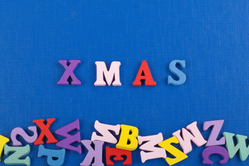 XMAS word on blue background composed from colorful abc alphabet block wooden letters, copy space for ad text. Learning english concept.