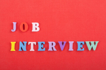 JOP INTERVIEW word on red background composed from colorful abc alphabet block wooden letters, copy...