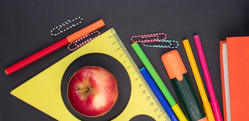 Back to school. Stationery on a black table. Office desk with copy space. Flat lay. Banner.