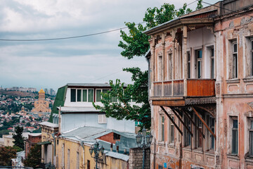 View of the Sameba Cathedral and a traditional Georgian wooden balcony from Mtatsminda neighborhood in Tbilisi, Georgia
