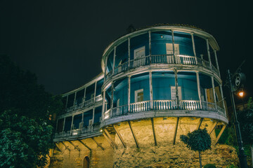 Old traditional Georgian house with wooden balcony in old Tbilisi (Georgia) by night - obrazy, fototapety, plakaty