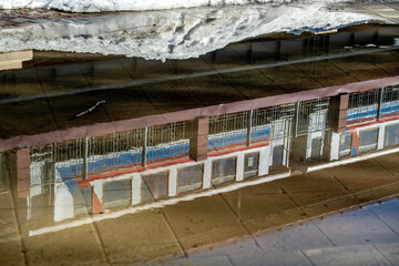Reflection of a railway carriage at the station in a puddle.