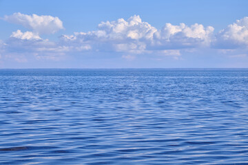 Fototapeta na wymiar Blue sea and white clouds on sky.