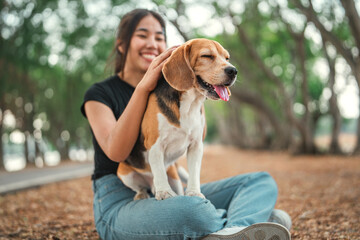 Happy asian woman playing with dog together in public park outdoors, Friendship between human and their pet	