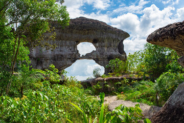 Iconic Puerta de Orion rock formation amidst lush greenery under a cloudy sky in San Jose del...