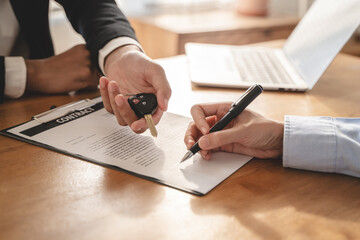 Business car rental company service, Close up hand of agent dealer giving, holding car key to customer renter, new owner after signed rental, purchase contract in document, vehicle sales agreement. - obrazy, fototapety, plakaty
