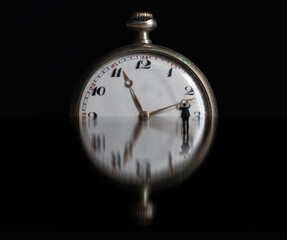 Bussiness man in suit holding clock hand on reflection surface. Stop time concept, deadline - 791826228