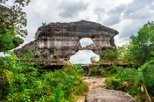 Iconic Puerta de Orion rock formation amidst lush greenery under a cloudy sky in San Jose del Guaviare, Colombia