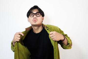 Young Asian man showing arrogant gesture while touching his shirt