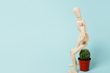 Haemorrhoids. wooden man sitting on a cactus.Vascular structures in the lower part of the rectum and acute pain concept, blue background with copy space - obrazy, fototapety, plakaty