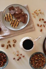 Cup of tea or coffee, cookies, macaroons, chocolate, various nuts and cocoa powder on white...