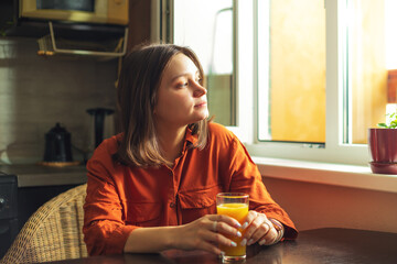 Portrait of a pretty woman with a glass of orange juice. - 791838816